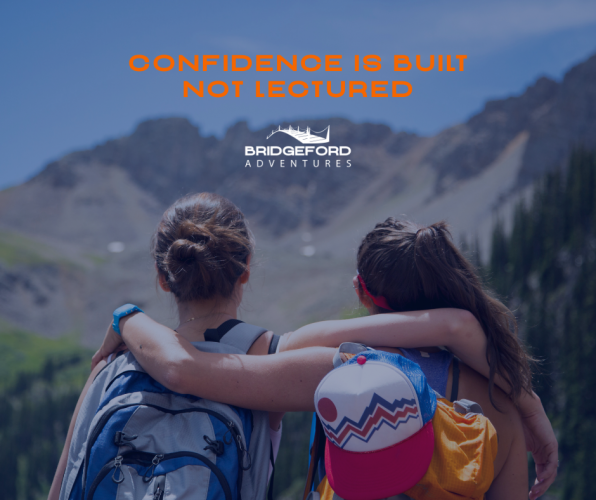 Two teens are looking at a mountain.